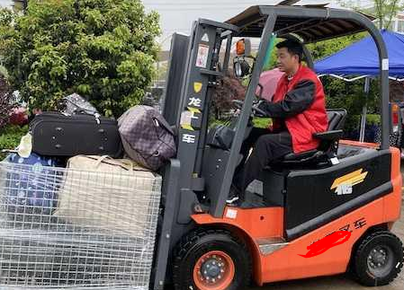 物流專(zhuān)業(yè)學(xué)生學(xué)以致用,用手動(dòng)搬運(yùn)車(chē)運(yùn)送行李